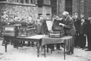 A group of children at a Barnardo’s orphanage in Liverpool have their luggage inspected before their emigration to Canada.