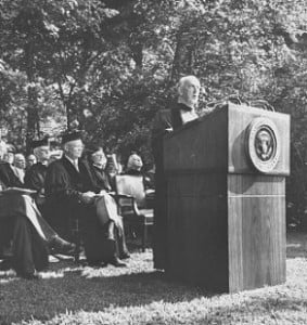 President Eisenhower, seated, listens as Geoffrey Fisher