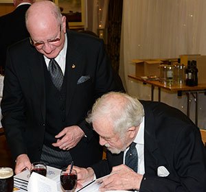 Tom Blackburn (seated) ‘autographs’ a copy of the lodge history for David Grainger. Lancaster-Longridge-has-a-lot-to-celebrate-Pic-3 V2