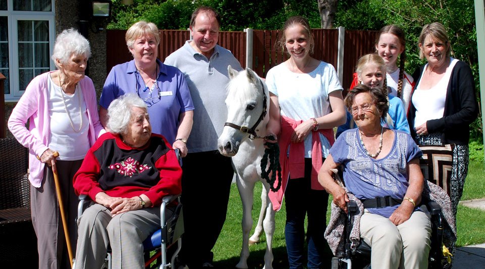 Pictured are: Mary Piert (second left back row), Graham Chambers (centre) and his family, with residents of Tithebarn and Rosie the pony.