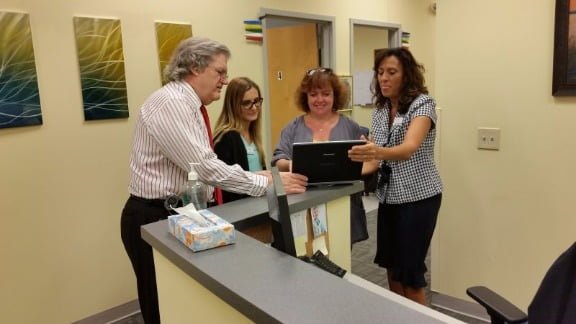 Dr. Roeltgen consults with staff members at the facility. More employees are expected to be added in about six months.