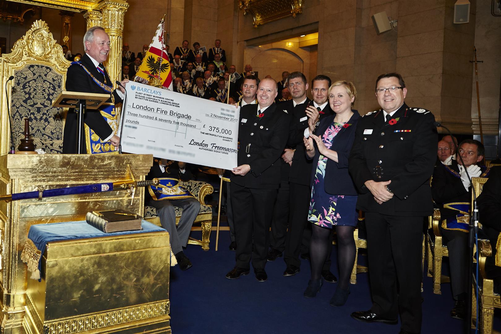 Picture of Sir Michael Snyder, the Metropolitan Grand Master presented the first instalment of £375,000 to Steve Apter, London Fire Brigade Director of Safety and Assurance.